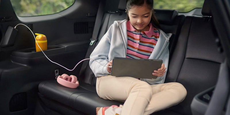 Child playing with tablet in Grand Highlander Hybrid